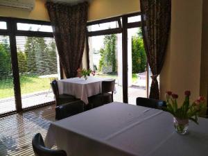 a dining room with a table and a large window at Jaśminowy Gaj in Inowrocław