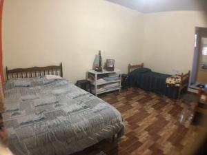 Schlafzimmer mit einem Bett und Holzboden in der Unterkunft Casa Benta in Aparecida