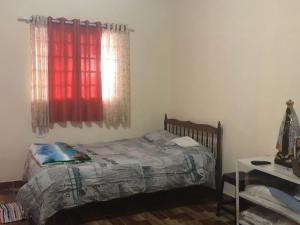 a bedroom with a bed and a red window at Casa Benta in Aparecida