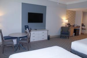 a hotel room with a bed and a table and a television at Carlisle Inn Sarasota in Sarasota