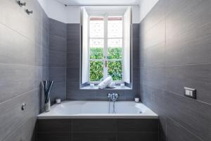 een badkamer met een bad en een raam bij A World Aparts - 32 Calabria in Rome