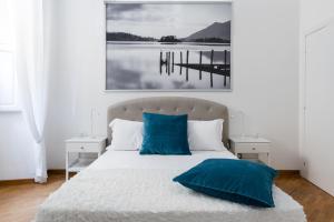 een slaapkamer met een bed met blauwe kussens en een pier bij A World Aparts - 32 Calabria in Rome