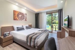 ネオス・マルマラスにあるPoseidon Hotel Sea Resortのベッドとテレビがあるホテルの部屋 +37枚の写真