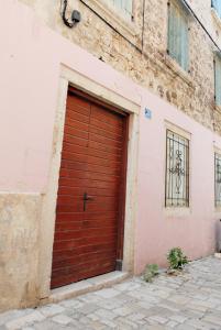 une porte de garage rouge sur le côté du bâtiment dans l'établissement Apartman tutto bene, à Rovinj