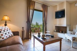 a living room with a couch and a table and a tv at Thelxis Villa in Lourdhata