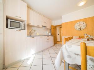 eine Küche und ein Esszimmer mit einem Tisch und einer Mikrowelle in der Unterkunft Maison Ostaria MyHolidayLivigno in Livigno