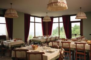 a dining room with tables and chairs and windows at Alle tre Colline in Albugnano 