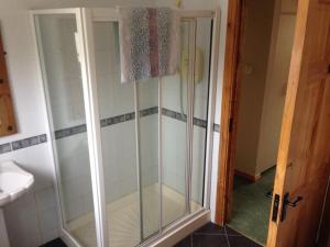 a shower with a glass door in a bathroom at Poppyfield House, Kenmare in Kenmare