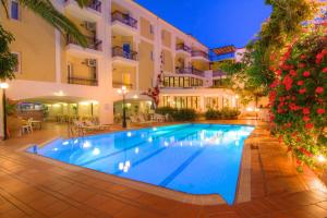 una piscina frente a un hotel por la noche en Fortezza Hotel, en Rethymno