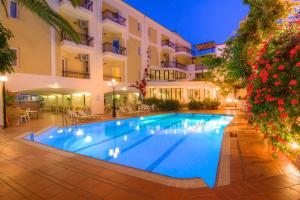 a swimming pool in front of a hotel at night at Fortezza Hotel in Rethymno