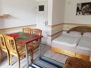 a room with a table and a bed and a table and chairs at Domek letniskowy Mauritius in Mielno