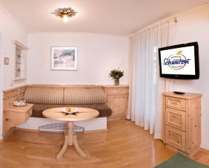 salon ze stołem i telewizorem w obiekcie Biohotel Schweitzer w mieście Mieming