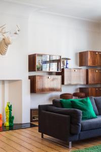 sala de estar con sofá azul y armarios de madera en B&B - Apartment - Peace in the City, en Amberes