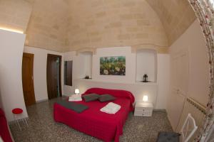 ラテルツァにあるIl Rifugio di Laerteの赤いベッドと壁に絵画が飾られたベッドルーム1室