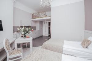 a small bedroom with a bed and a table and a desk at Apartamenty Bonerowska 5 in Krakow