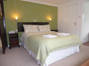 a bedroom with a bed with two towels on it at Neuadd Wen Guest House in Carmarthen