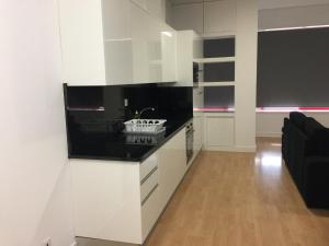 a kitchen with white cabinets and a black counter top at Invicta House Maia in Maia