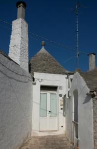 biały budynek z drzwiami i dachem w obiekcie Trullo Alberobello Vacanze Desà 1 w Alberobello