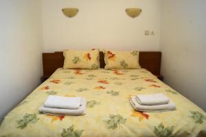 a bedroom with a bed with towels on it at Guest House Perla in Bachkovo
