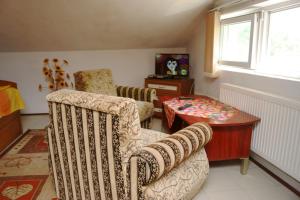 uma sala de estar com duas cadeiras e uma mesa em Guest House Perla em Bachkovo