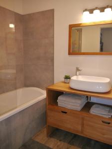 a bathroom with a sink and a bath tub at Au cœur du Bassin d'Arcachon in Gujan-Mestras