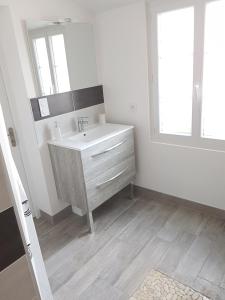 a white bathroom with a sink and a mirror at LA MAISON D'ALIDA in Nueil-sous-Faye
