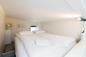 a white bed with white sheets and pillows at GreenKey Apartment SK2 in Reykjavík