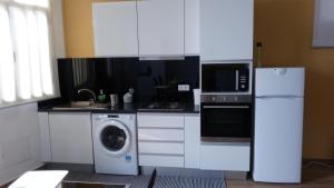 a kitchen with a refrigerator and a washing machine at Casa do Carvoeiro II-GOOD AND CHEAP!!! in São Vicente