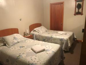 a room with two beds with towels on them at Hospedaje Baquedano in Puerto Natales