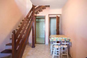 a dining room with a table and a staircase at Edificio caminho do sol in Arraial do Cabo