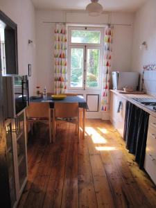 een keuken met een tafel en een houten vloer bij Zwischen-Rhein-und-Reben, zentral, barrierefrei in Speyer