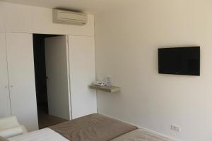Hostalet de Begur - Adults Only في بيغور: غرفة بها سرير وتلفزيون على الحائط