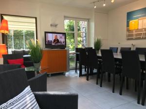 een eetkamer met een tafel en stoelen en een tv bij Holiday Home New Largo in Nieuwpoort