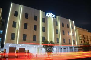 a hotel building with a sign on it at night at MJ Apartments in Al Khobar