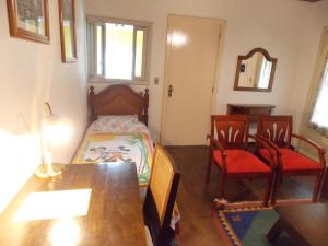 1 dormitorio con 1 cama, mesa y sillas en Casa para 5 pessoas em Canela - Caracol, en Canela