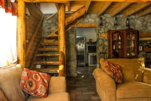 una sala de estar con sofás y escaleras en una cabaña en Hospedaje Andorra La Vella en Ushuaia
