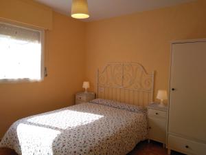 um quarto com uma cama e duas mesas de cabeceira e uma janela em Casa Galilea em Galilea