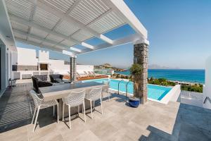 a patio with a table and chairs and a swimming pool at Villa Armonia in vlicha
