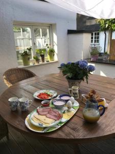 侯維肯的住宿－Bed & Breakfast Höllviken，一张木桌,上面有盘子的食物