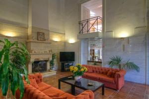 a living room with orange couches and a fireplace at Fortezza Hotel in Rethymno