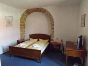 Schlafzimmer mit einem Bett, einem Tisch und einem TV in der Unterkunft Hotel "Zur Sonne" in Querfurt