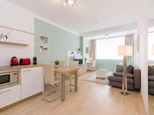 a kitchen and living room with a table and a couch at Christian Apartments Oper - contactless check in - by Arbio in Vienna