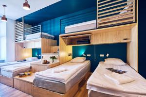 two beds in a room with blue walls at Draggo House - Premium Rooms - Old Town in Krakow