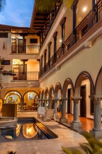 an indoor courtyard with a pool in a building at Hotel Colonial in San José