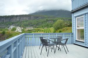 a balcony with chairs and a table with a view of a mountain at Apartment 2, Herand, Hardanger in Herand