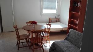ヴァンヌにあるAppartement Prat Lannのテーブル、椅子、ベッドが備わる客室です。