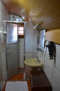 a small bathroom with a sink and a shower at Ex Pousada Vale do Bosque - Aluguel por temporada in Gramado