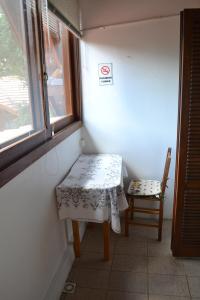 格拉馬杜的住宿－Ex Pousada Vale do Bosque - Aluguel por temporada，窗户客房内的小桌子和椅子