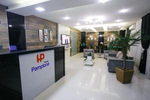 a hotel lobby with a waiting area with a potted plant at Hotéis Pamplona in Rio do Sul