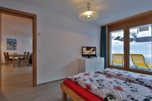 ツェルマットにあるフェリエンヴォーヌング シュタインマットシュトラッセのベッドルーム1室(ベッド1台、テーブル、椅子付)